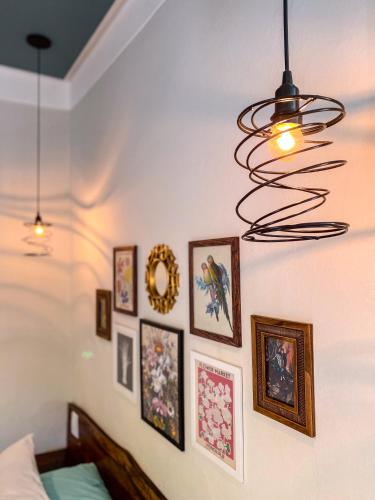 a bedroom with pictures on the wall and a chandelier at Bica D' Água Boutique Hotel in Capitólio