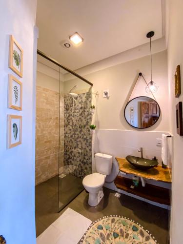 a bathroom with a toilet and a sink and a shower at Bica D' Água Boutique Hotel in Capitólio