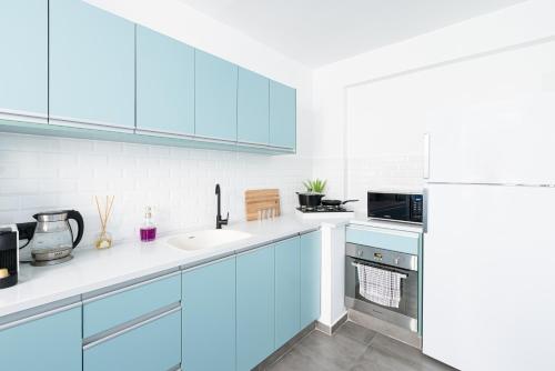 eine blaue Küche mit einer Spüle und einem Kühlschrank in der Unterkunft Oazis 1BR Apt,Central Old Town, Great location in Be’er Scheva