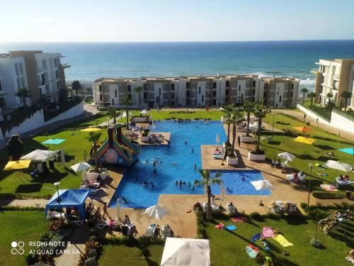 una vista aérea de una piscina en un complejo en Appartement Plage des Nations Prestigia Front Mer avec grand Jardin en Sidi Bouqnadel