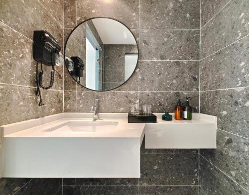 La salle de bains est pourvue d'un lavabo blanc et d'un miroir. dans l'établissement Holiday Inn Guoshang, à Jianyang
