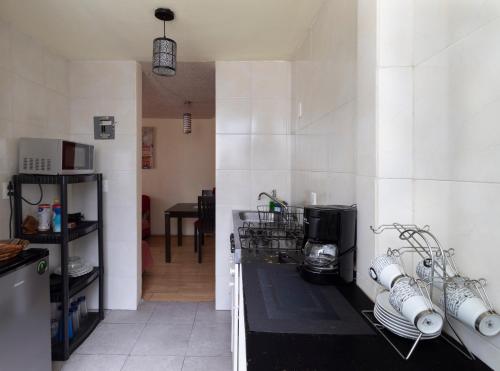 メキシコシティにあるDepartamento ubicado en el centro histórico CDMXの白い壁のキッチン、食器カウンター