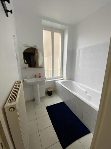 une salle de bain blanche avec une baignoire et un lavabo dans l'établissement Un moment de Détente au cœur de Vals-les-Bains, à Vals-les-Bains