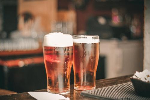 two glasses of beer sitting on a table at Holiday Inn Express & Suites - Kokomo South by IHG in Kokomo