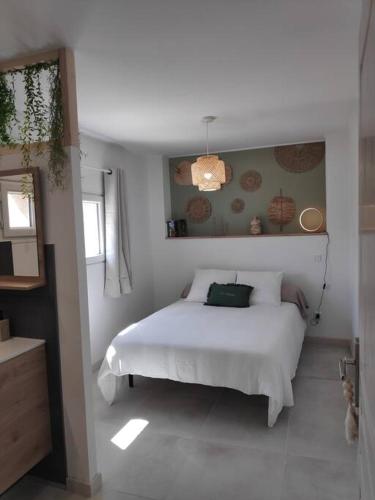 une chambre avec un lit blanc dans une pièce dans l'établissement Maison indépendante avec terrasse, jardin & parking privé, à Hérépian