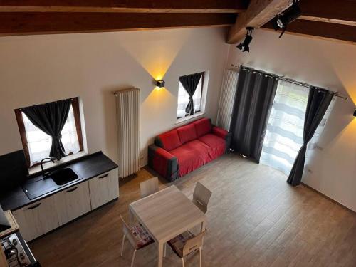 a living room with a red couch and a table at La Casa Di Emy in Alfedena