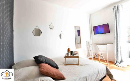 ein Schlafzimmer mit einem Bett und einem TV an der Wand in der Unterkunft Ch2 communs à partager Seh’Loué in Saint-Brieuc