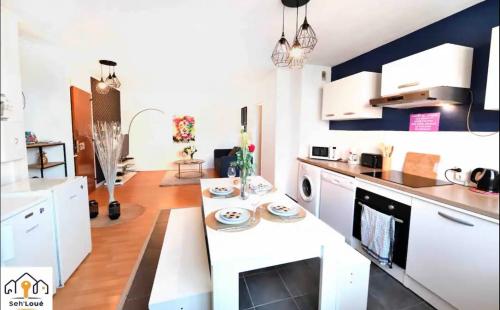 eine Küche mit weißen Schränken und einer Arbeitsplatte in der Unterkunft Ch2 communs à partager Seh’Loué in Saint-Brieuc
