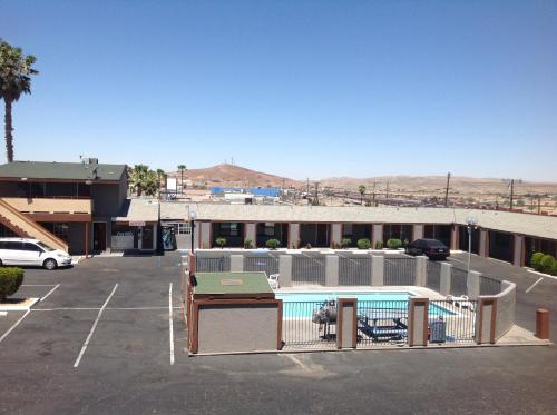 a parking lot with a swimming pool and a building at Budget Inn On Historic Route 66, Barstow in Barstow