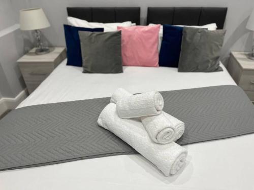 Una cama con dos toallas plegables. en Modern & Spacious 2 bed Apartment at Addison Court - Sleeps 6, Free WIFI, en Watford