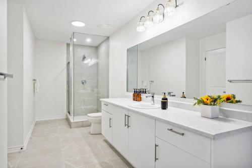 a white bathroom with a sink and a toilet at Barrie Luxe, Pool Table 6 BR 6 BA Custom Design A+ Location in Barrie