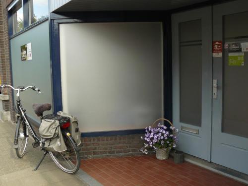 a bike parked in front of a building with a door at Apartment Campinor in Pelt