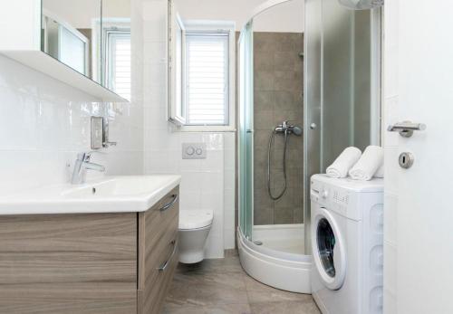 a bathroom with a sink and a washing machine at Apartments Katic in Ražanj