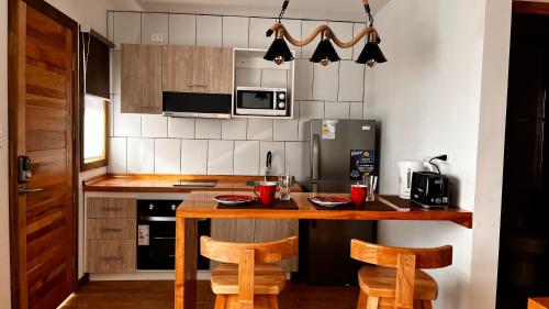 a kitchen with a wooden table and two chairs at Origenes Apartments in Puerto Natales