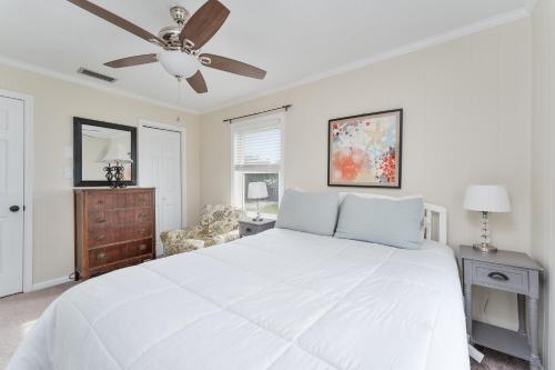 een slaapkamer met een wit bed en een plafondventilator bij 5212A - Cottons Cabana by Resort Realty in Kill Devil Hills
