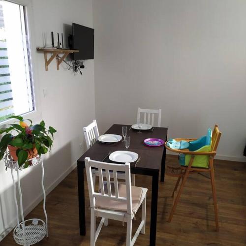 une salle à manger avec une table et des chaises noires dans l'établissement Appartement indépendant, calme 2 adultes, 2 étoiles, à Fleuré