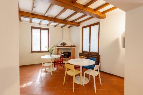 a living room with two tables and chairs and a fireplace at Il Nido sul Po in Casalmaggiore