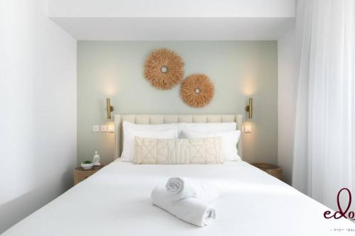 een slaapkamer met een groot wit bed met witte kussens bij Family apartment next to the sea - By Edom in Eilat
