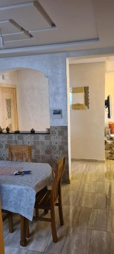 Résidence nahda في أغادير: غرفة بطاولة وكراسي وجدار