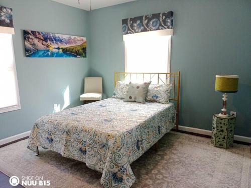 a blue bedroom with a bed and a window at Tranquility Place in Kannapolis