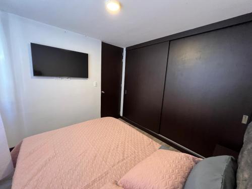 a bedroom with a bed and a flat screen tv at Apartamento Centro de Manizales in Manizales