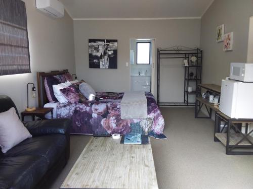 a living room with a bed and a couch at Chris and Dave's B & B in Otorohanga