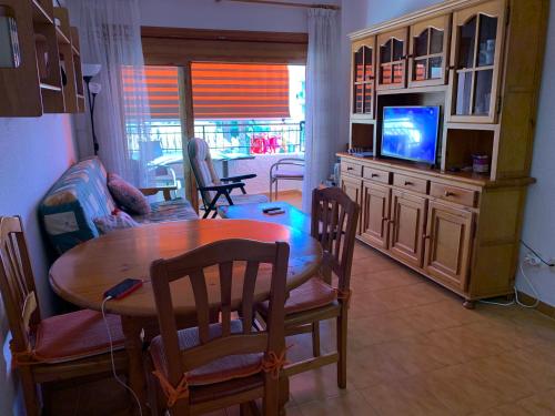 un salon avec une table et une télévision dans l'établissement RELAX en SANTA POLA, ALICANTE, à Santa Pola