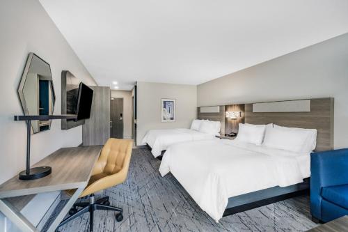 a hotel room with two beds and a desk and a tv at Holiday Inn Express & Suites - Nephi, an IHG Hotel in Nephi