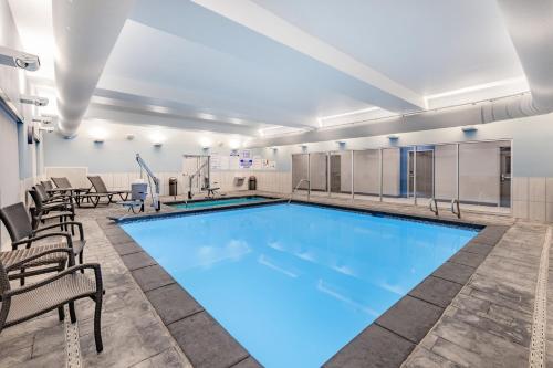 a swimming pool with chairs and a table at Holiday Inn Express & Suites - Nephi, an IHG Hotel in Nephi