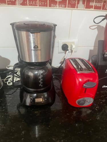 a red blender sitting on a counter next to a toaster at Manolo in Santa Rosa