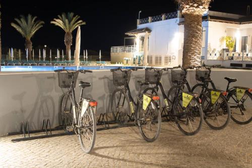 a group of bikes parked next to a wall at Happy Tavira Apartments - Apartamento Inspire Cabanas no Resort Golden Club in Cabanas de Tavira
