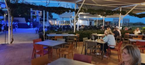people sitting at tables in a restaurant at night at Happy Tavira Apartments - Apartamento Inspire Cabanas no Resort Golden Club in Cabanas de Tavira
