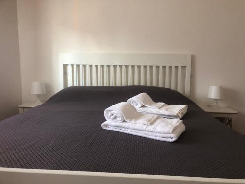a bed with towels sitting on top of it at Aurasol Alghero in Alghero