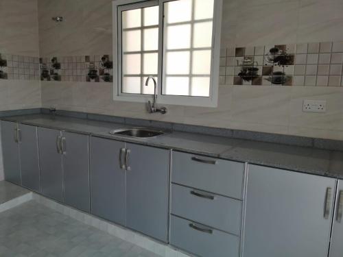 a kitchen with a sink and a window at فيلا مسقط - Muscat Villa in Bawshar