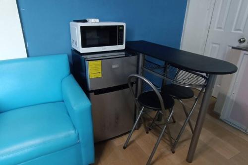 a blue room with a table with a microwave and a chair at Suite Estudio 2 Buena Vista Santa Tecla in Nueva San Salvador