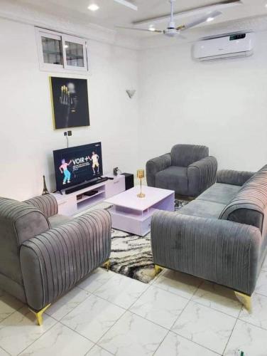 sala de estar con sofás y TV de pantalla plana. en Agimlog, en Allada