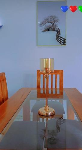 a glass table with a candle on top of it at Agimlog in Allada