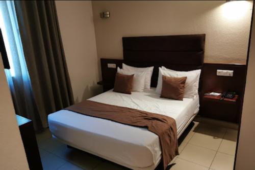 ein Schlafzimmer mit einem großen Bett in einem Hotelzimmer in der Unterkunft HOTEL DU NORD in Bejaïa