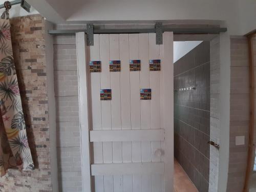 a bathroom with a white door in a room at Casa Terra Cota - Sesimbra in Cotovia