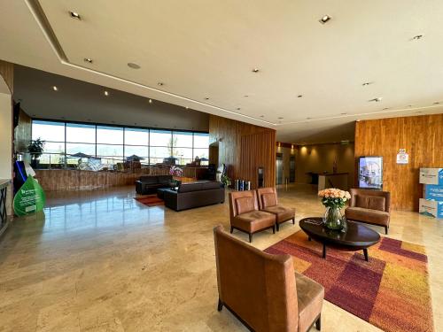 a lobby with chairs and a table in a building at Wyndham Quito Airport in Tababela