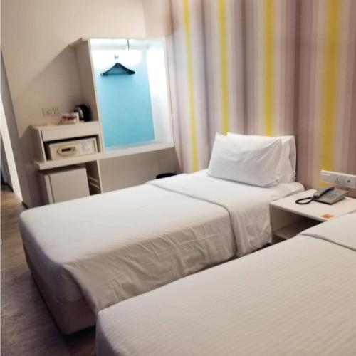 Pokój hotelowy z 2 łóżkami i lustrem w obiekcie Room in Genting Highland w mieście Genting Highlands