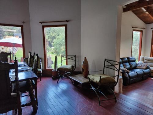 ein Wohnzimmer mit einem Tisch, Stühlen und einem Sofa in der Unterkunft Un paraíso en la montaña Bogotá Verjon Via La Calera in Bogotá