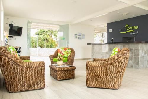 a lobby with wicker chairs and a counter at Hotel Entre Lomas in Santa Rosa de Cabal