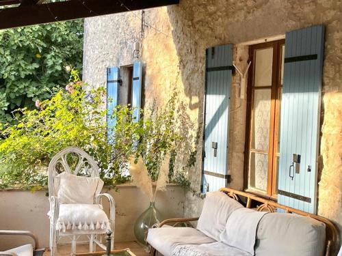porche con 2 sillas, sofá y ventana en Fabulous 2 bed Gite 2km quiet Walk into Eymet, en Eymet