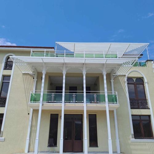 un bâtiment avec un balcon au-dessus dans l'établissement Gonadze Vineyards Hotel, à Ambrolaouri