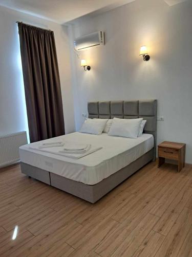 Gonadze Vineyards Hotel في أمبرولاوري: غرفة نوم بسرير كبير وستارة بنية اللون
