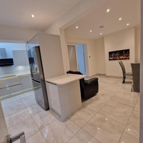 a kitchen and living room with a counter and chairs at Delightful & Spacious Guest House in Farnworth Near Bolton Hospital in Farnworth