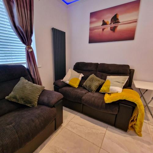 a living room with two couches and a couch at Delightful & Spacious Guest House in Farnworth Near Bolton Hospital in Farnworth