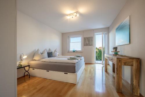 1 dormitorio con 1 cama grande y 1 mesa en Fewo Seeschwalbe, en Iznang