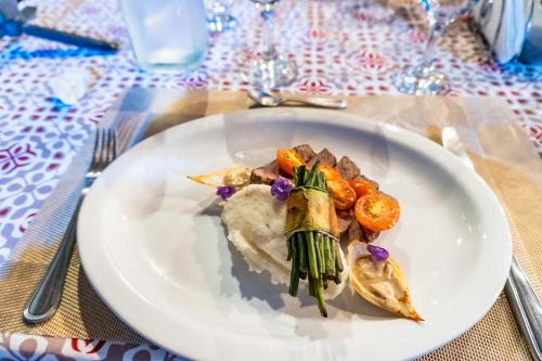 a plate of food with meat and vegetables on a table at Hidden Paradise Lodge in Drake